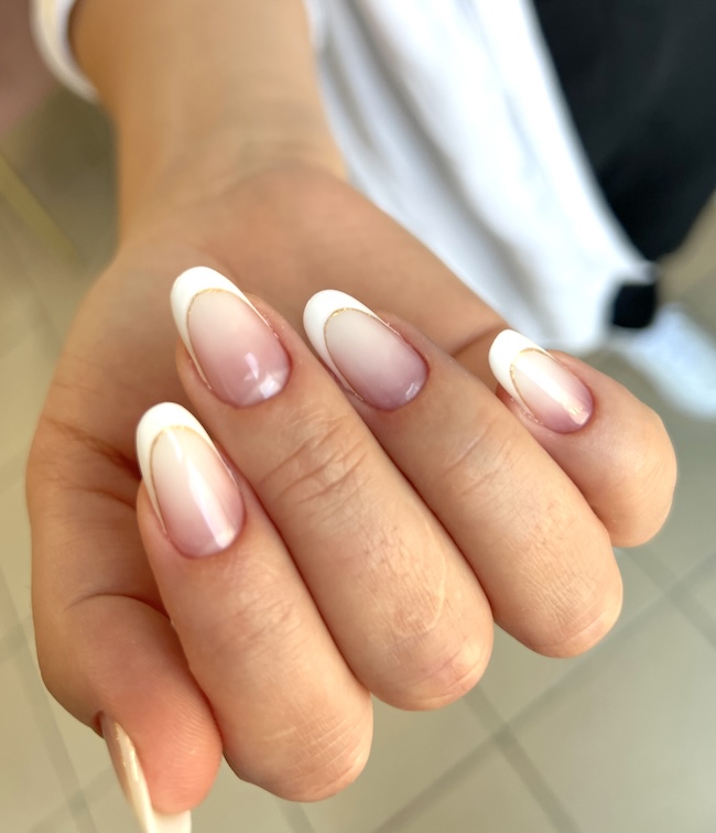 Gold-lined French tip nails.