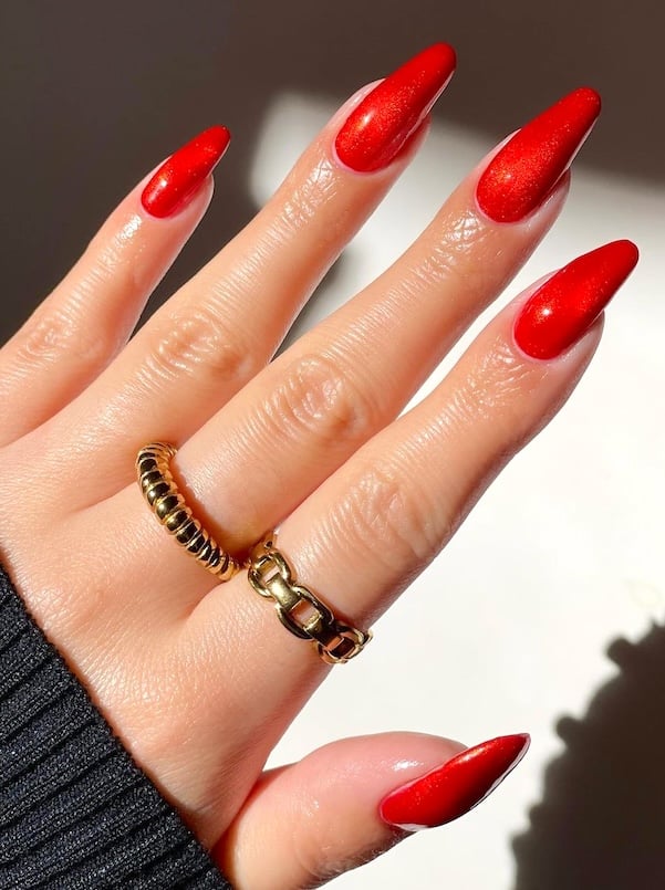 Long orange red shimmer nails.