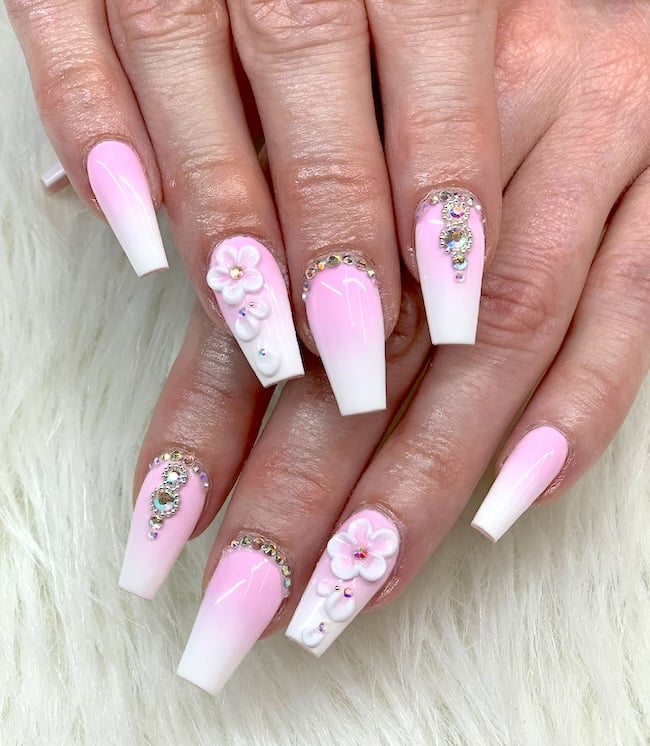 Embeliished 3D pink and white flower nails.