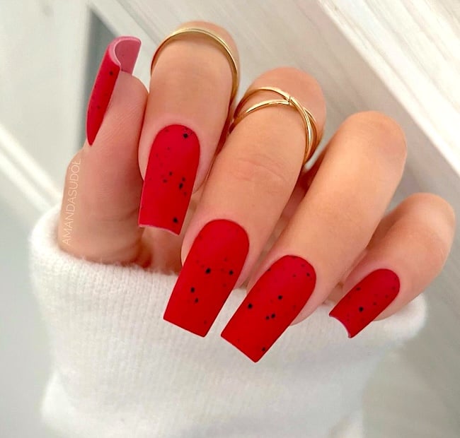 Red nails with black speckles.