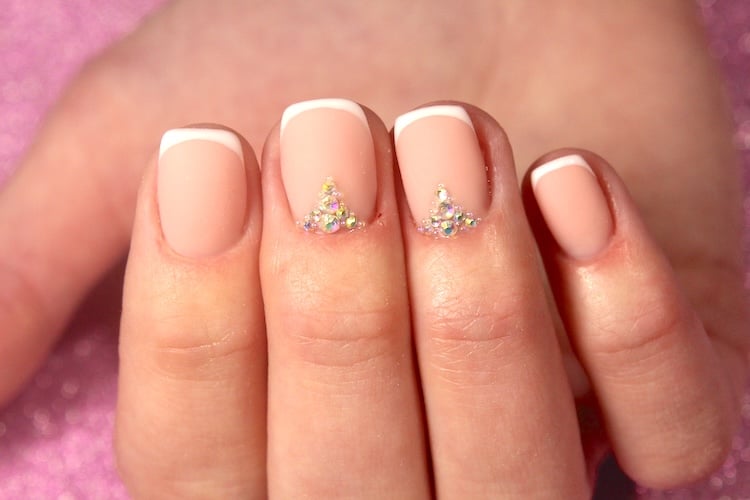 Short French tip nails with rhinestones.