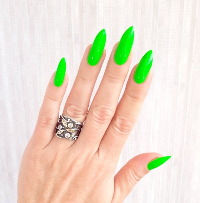 Bright green neon nails and silver ring.