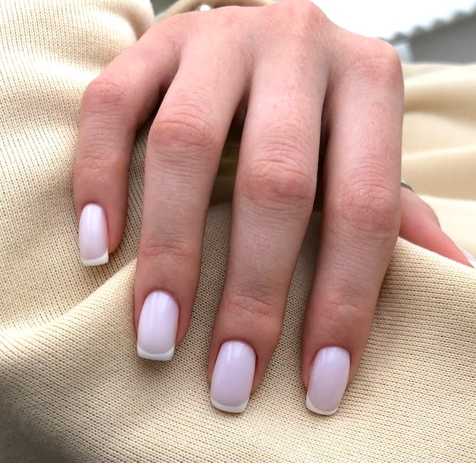 Pastel pink French tip nails.