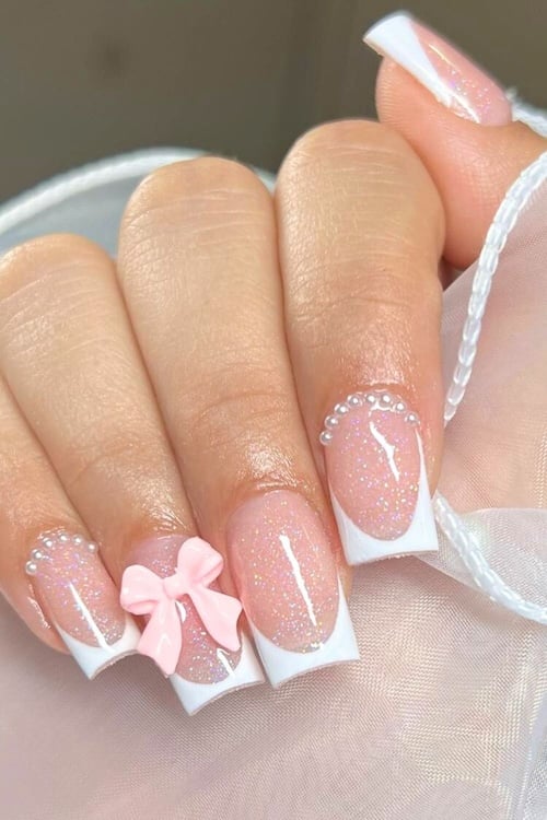 Pink bow French tip nails.