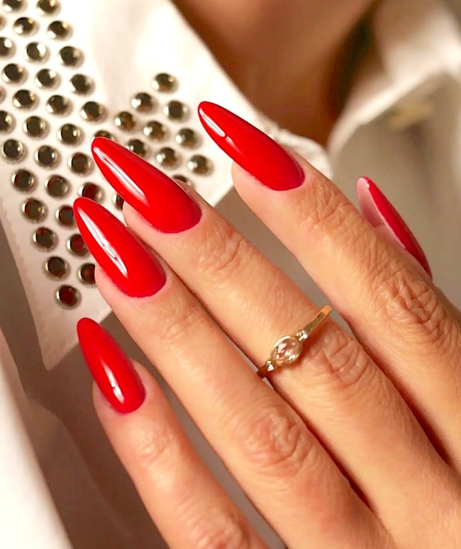 Classic long almond-shaped red nails.