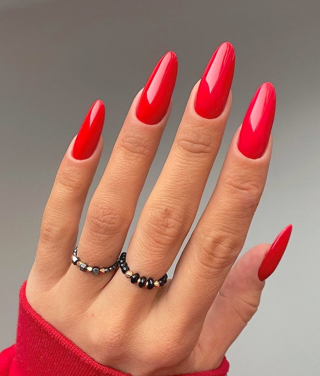 Long red nails, almond-shaped.