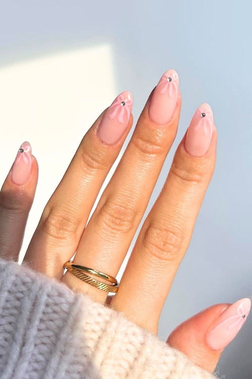 Pink bows with rhinestone nails.