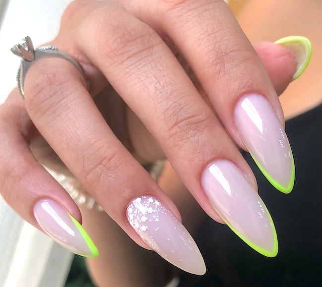 Sharp neon stiletto French tip nails.