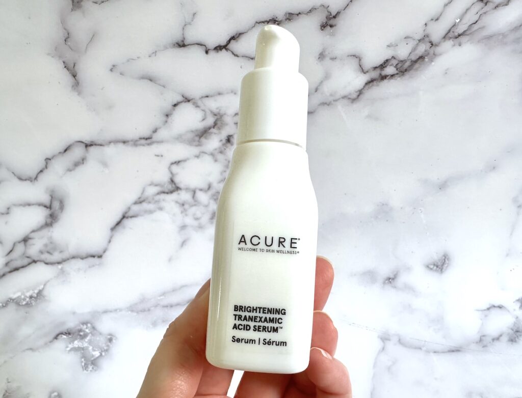 Acure Brightening Tranexamic Acid Serum, handheld.