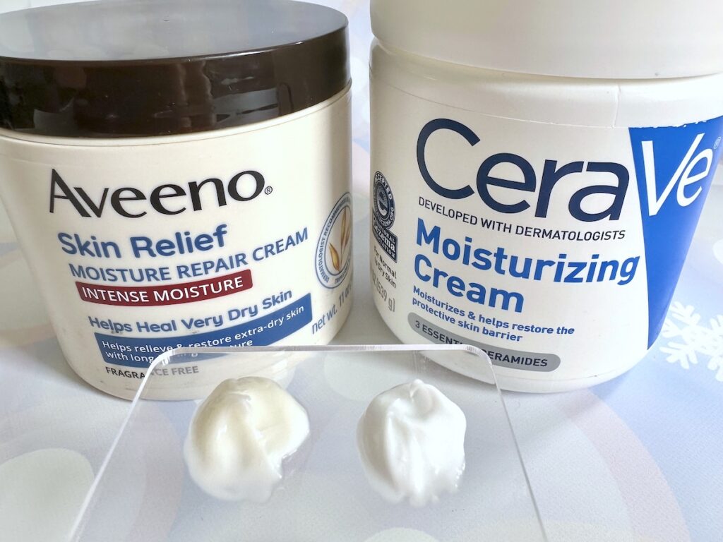 Aveeno Skin Relief Moisture Repair Cream and CeraVe Moisturizing Cream, with cream samples on clear spatula palette.