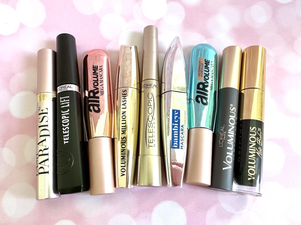 Flatlay of the best L'Oreal mascaras on pink twinkly background.