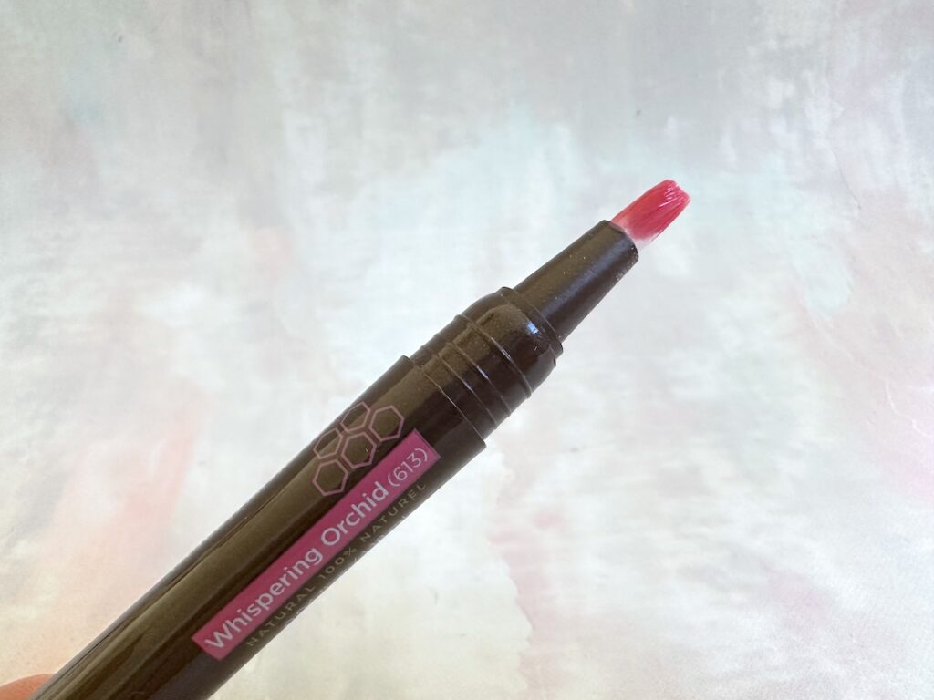 Burt's Bees Tinted Lip Oil in the shade Whispering Orchid, open with applicator brush.