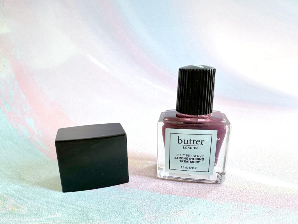 butter London Jelly Preserve Nail Strengthening Treatment in the shade Victoria Plum, cap removed.