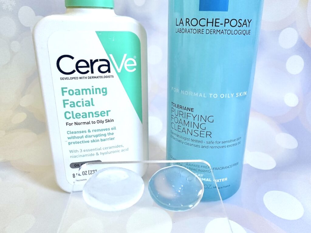 CeraVe Foaming Facial Cleanser vs La Roche-Posay Toleriane Purifying Foaming Facial Cleanser, bottles next to samples on clear cosmetic spatula.