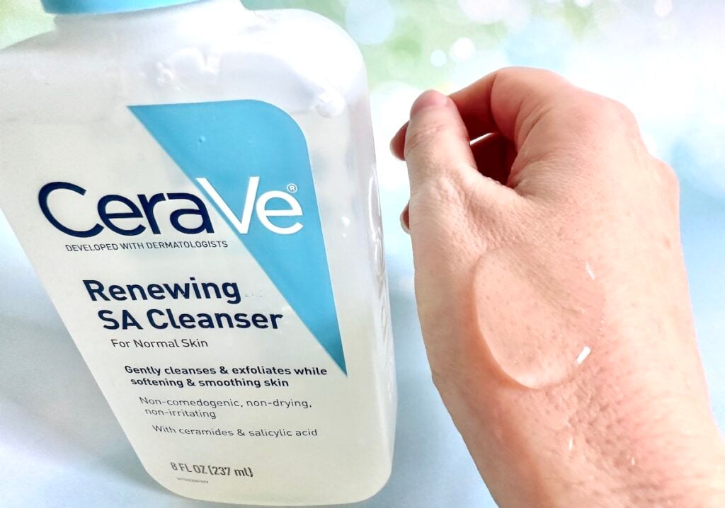 CeraVe Renewing SA Cleanser bottle next to gel sample on back of hand.