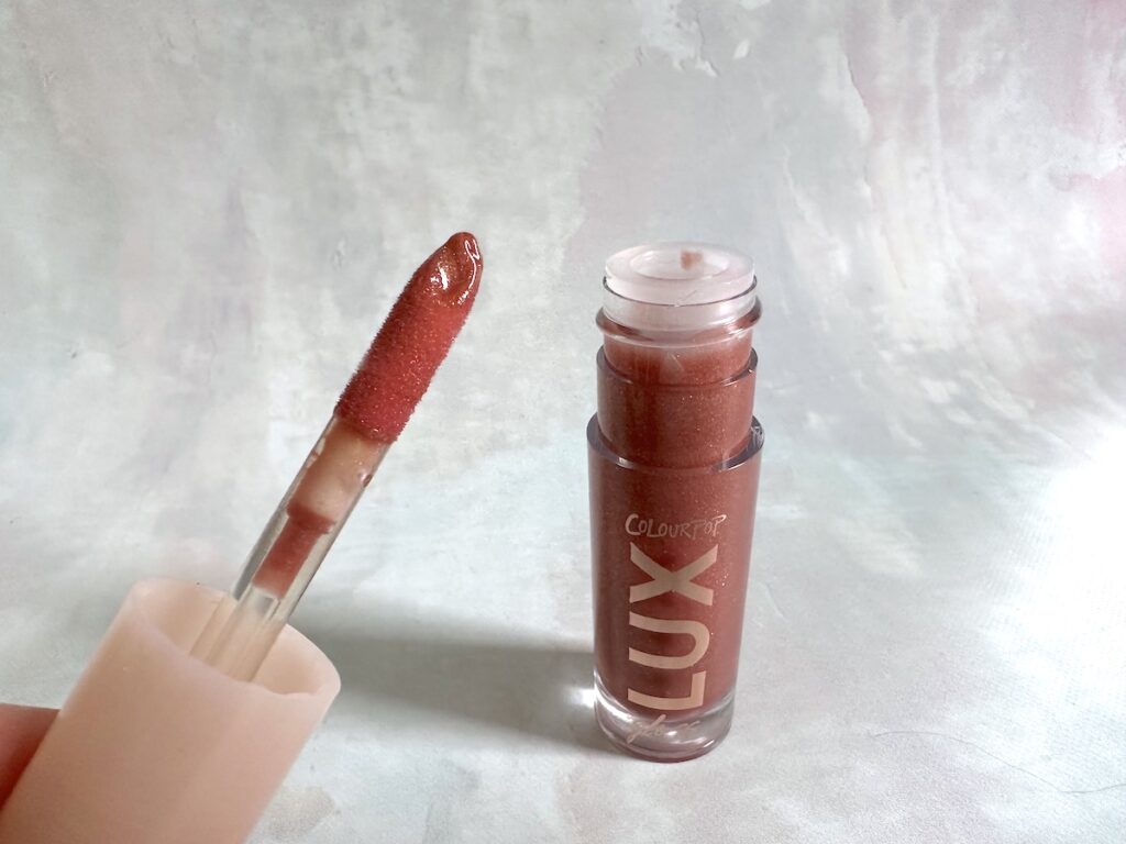 ColourPop Lux Lip Gloss in the shade Com Thru, open with applicator.