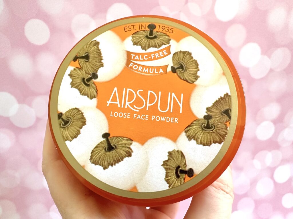 Coty Airspun Loose Powder in the shade Translucent, handheld.