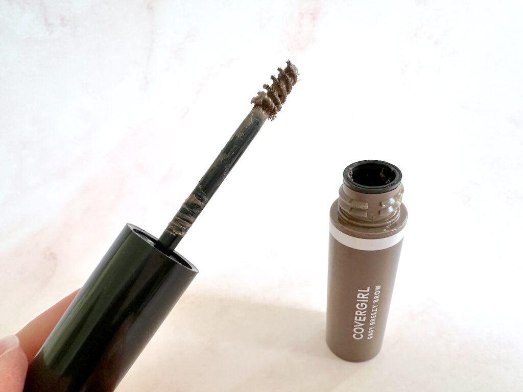 CoverGirl Easy Breezy Volumizing Brow Gel in teh shade Light. Open tube with applicator wand, handheld.