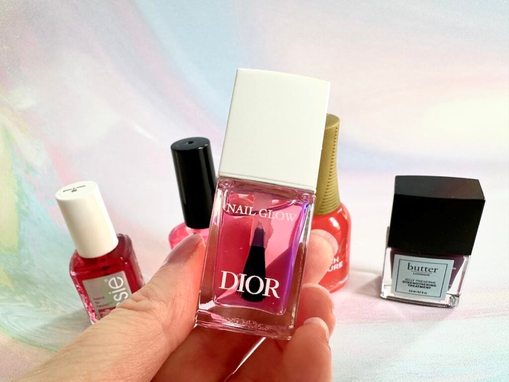 Dior Nail Glow dupes behind Dior Nail Glow nail polish, handheld.