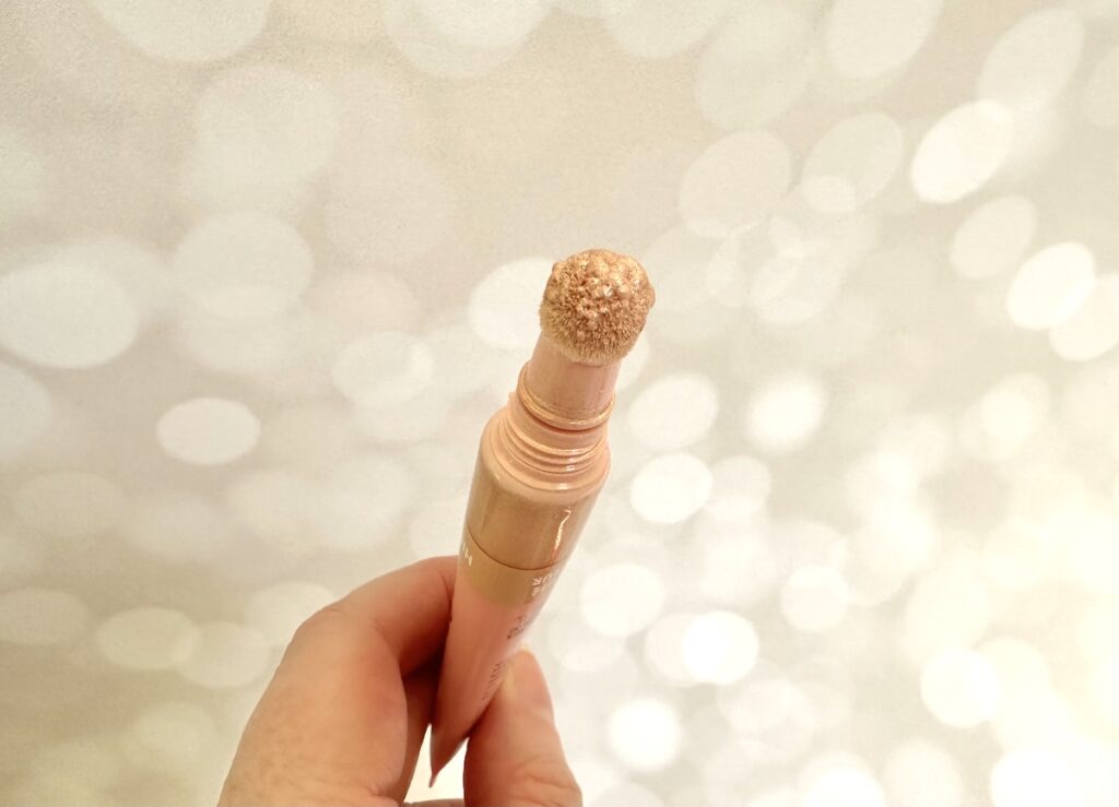 e.l.f. Halo Glow Highlight Beauty Wand in the shade Champagne Campaign, open tube with sponge applicator, handheld.