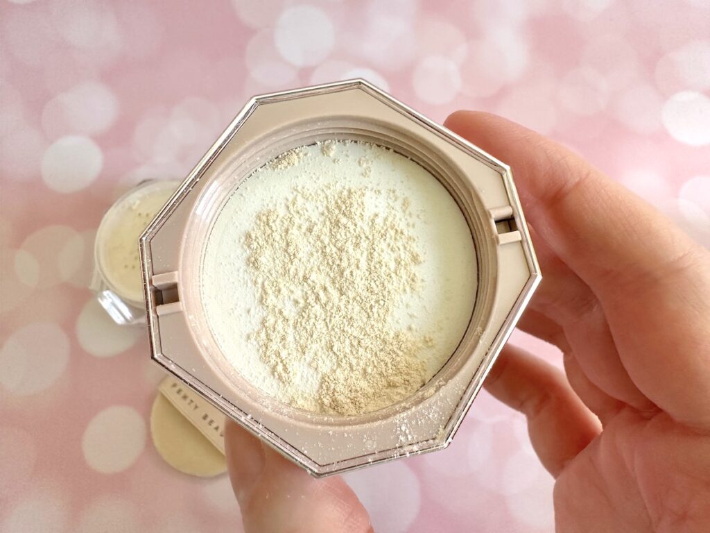 Fenty Pro Filt'r Instant Retouch Setting Powder in the shade Butter, powder sample on inside of lid, handheld.