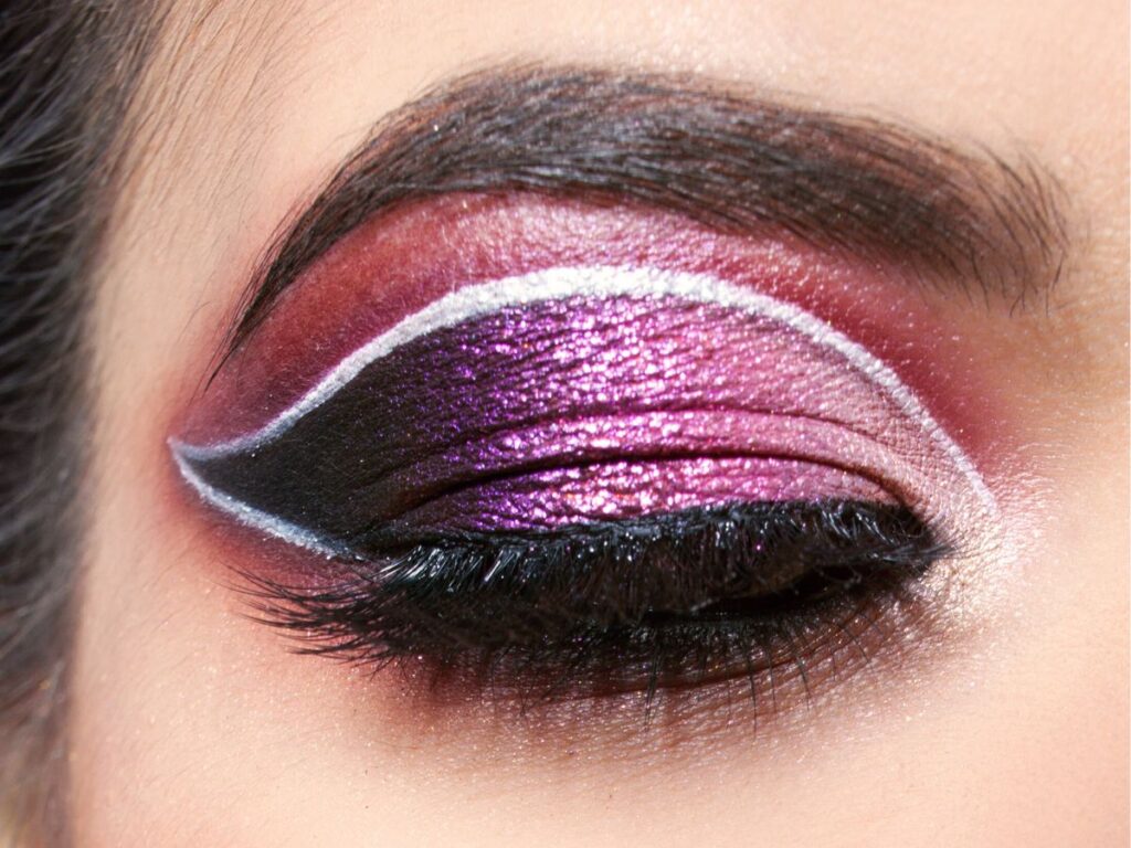 White lines and purple glitter eyeshadow on closed eye.