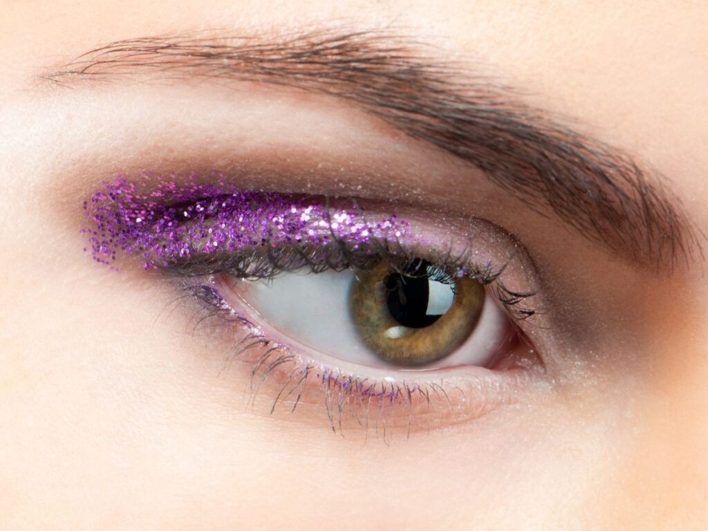 Half purple glitter eyeshadow on a brown eye. Minimal glittery eyeshadow look.