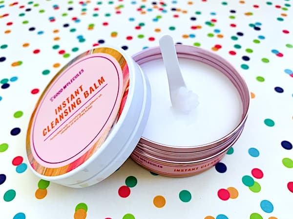 Good Molecules Instant Cleansing Balm open with spatula on colorful dot background