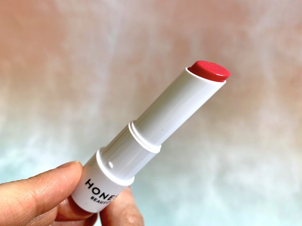 Honest Beauty Tinted Lip Balm opened in the shade Dragon Fruit.