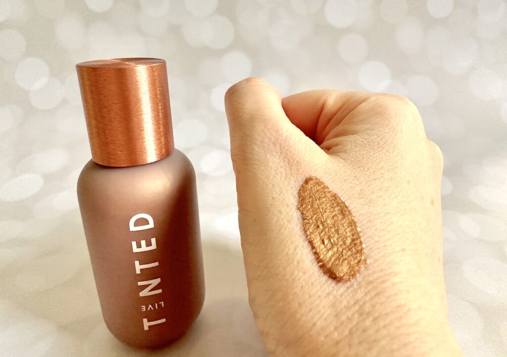 Live Tinted Hueglow Liquid Highlighter Drops in the shade Dusk, bottle next to sample on hand.