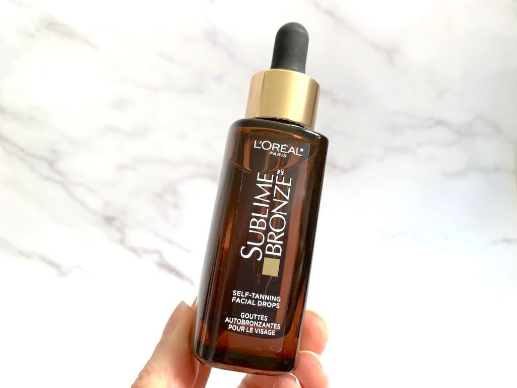 L'Oreal Sublime Bronze Self-Tanning Facial Drops held by hand