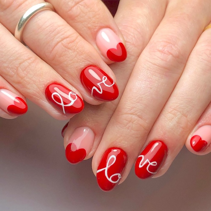 Crimson red nails with the word love written in cursive across two nails.