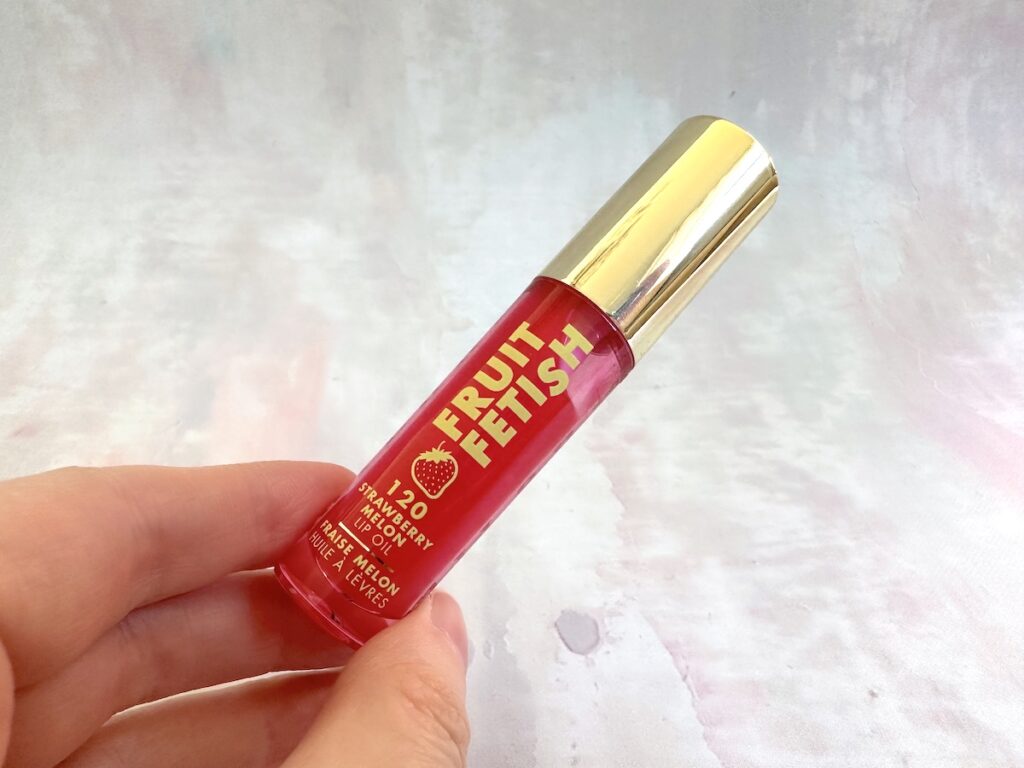 Milani Fruit Fetish Lip Oil in the shade Strawberry Melon, handheld.