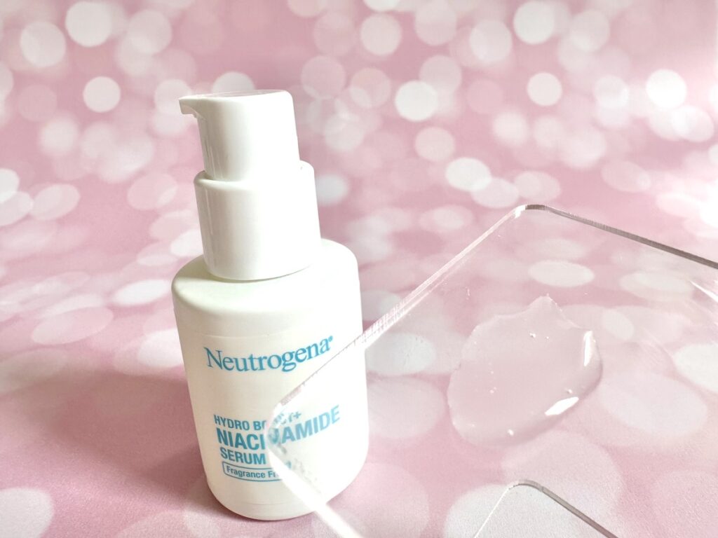 Neutrogena Hydro Boost + Niacinamide Serum, bottle next to sample on clear plastic cosmetic spatula.