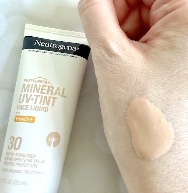 Neutrogena Purescreen+ Mineral UV-Tint Face Liquid Sunscreen SPF 30 in shade Light, flatlay of tube next to sample on hand.