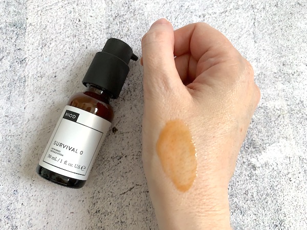 NIOD Survival 0 Antioxidant Serum bottle and sampled on hand