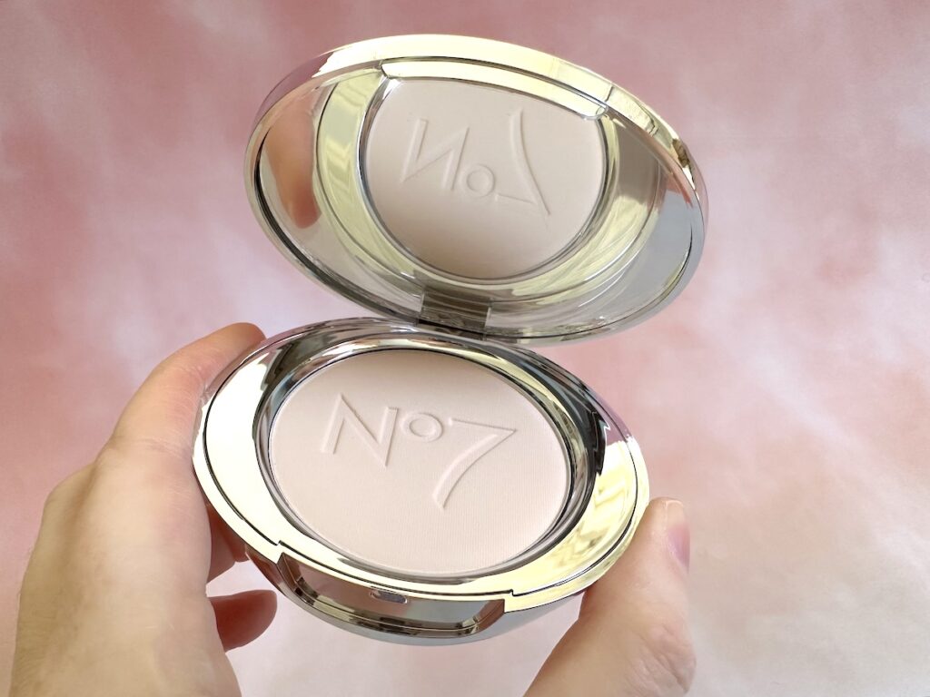 No7 Lift and Luminate Triple Action Finishing Powder in the shade Light, handheld.