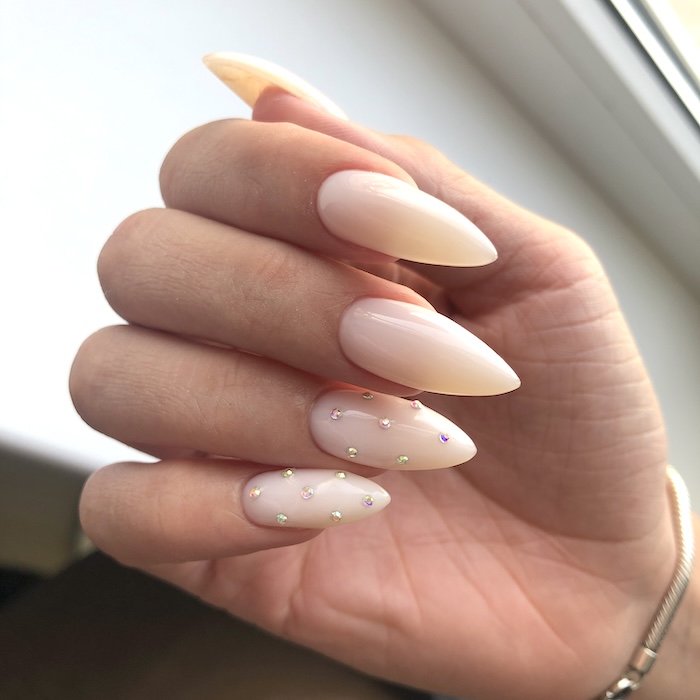 Rhinestone sparkle nude nails. Sharp stiletto nails.