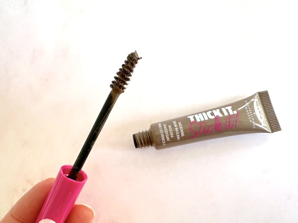 NYX Thick It. Stick It! Thickening Brow Mascara in the shade Taupe, open tube with applicator wand, handheld.