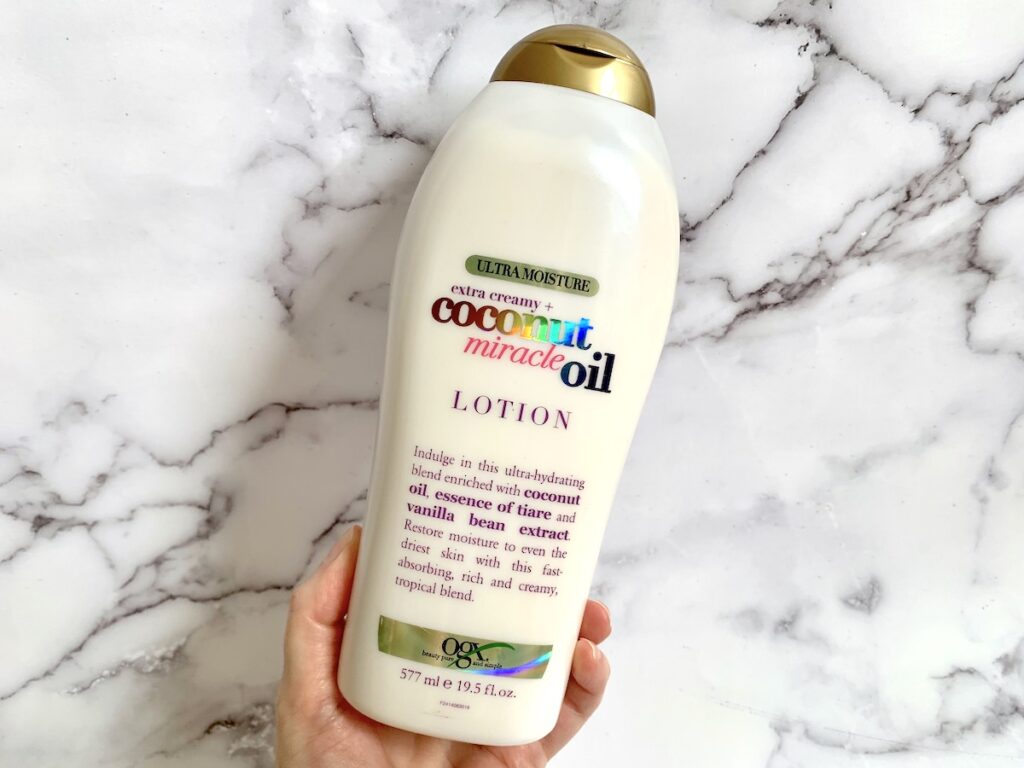 OGX Extra Creamy Coconut Miracle Oil Ultra Moisture Lotion handheld.