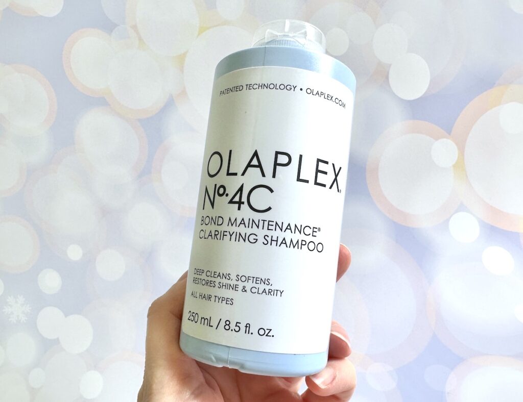 Olaplex No. 4C Bond Maintenance Clarifying Shampoo, handheld.