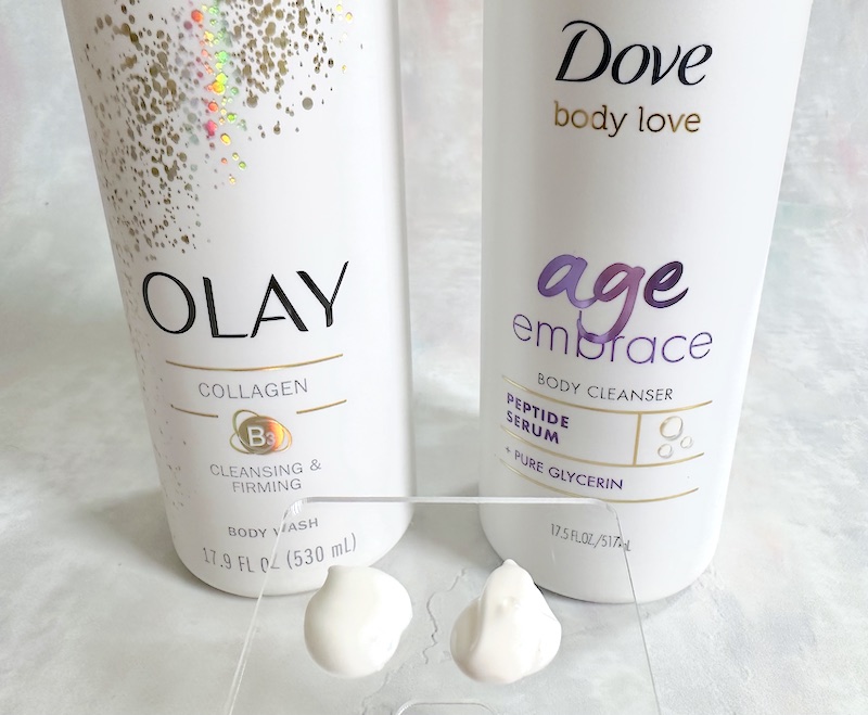 Olay Cleansing and Firming Body Wash and Dove Age Embrace Body Cleanser, sampled on clear spatula.