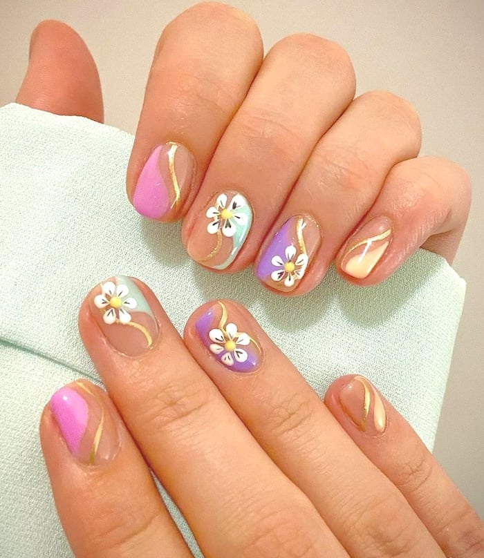 Short pastel abstract gold chrome daisy nails.