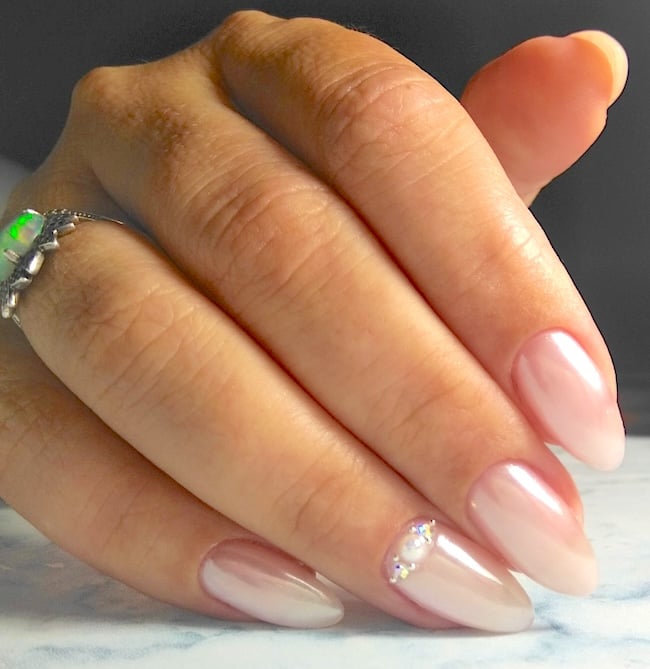 Pink pearl nails in an almond shape.