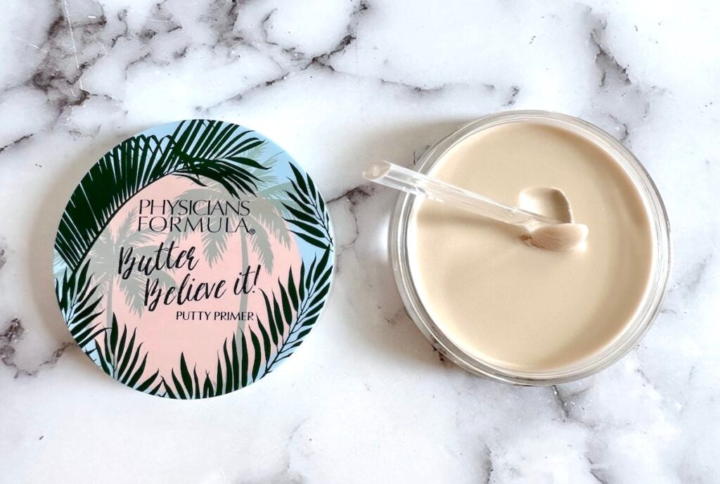 Physicians Formula Butter Believe It! Putty Primer, open jar with clear cosmetic spatula, flatlay.