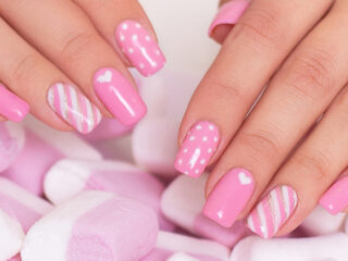 Pink and white nails next to pink and white candies.