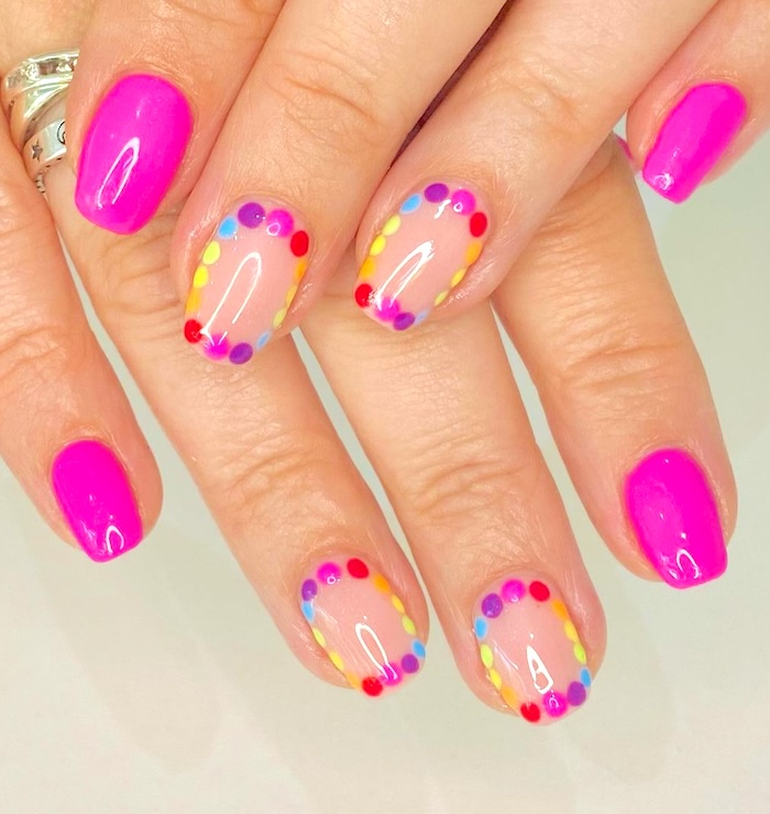 Bright pink rainbow circle nails.