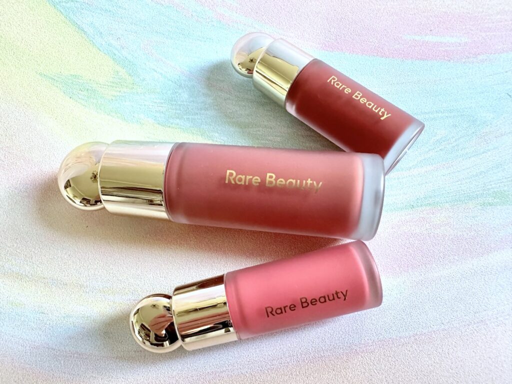 Rare Beauty Soft Pink Liquid Blush in the shades Truth, Encourage, and Happy, fanned flatlay.