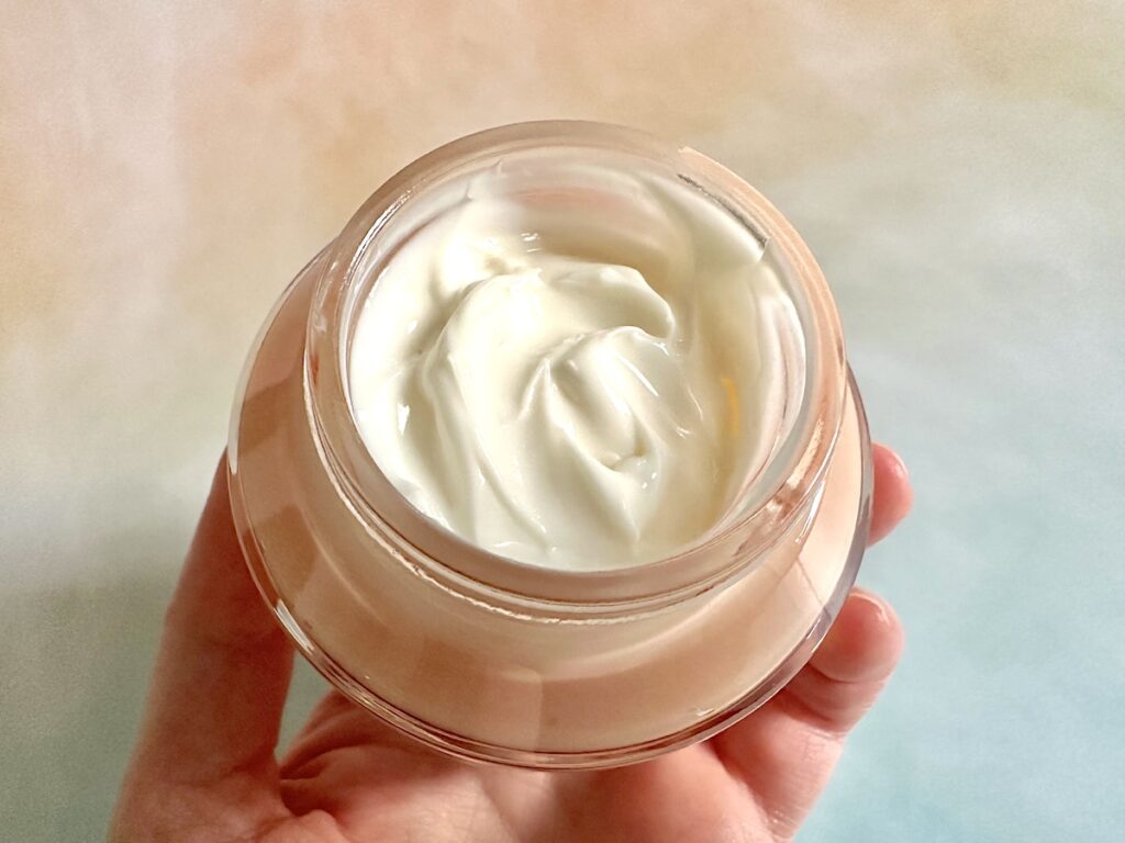 Revolution Pro Miracle Cream, open jar, handheld.