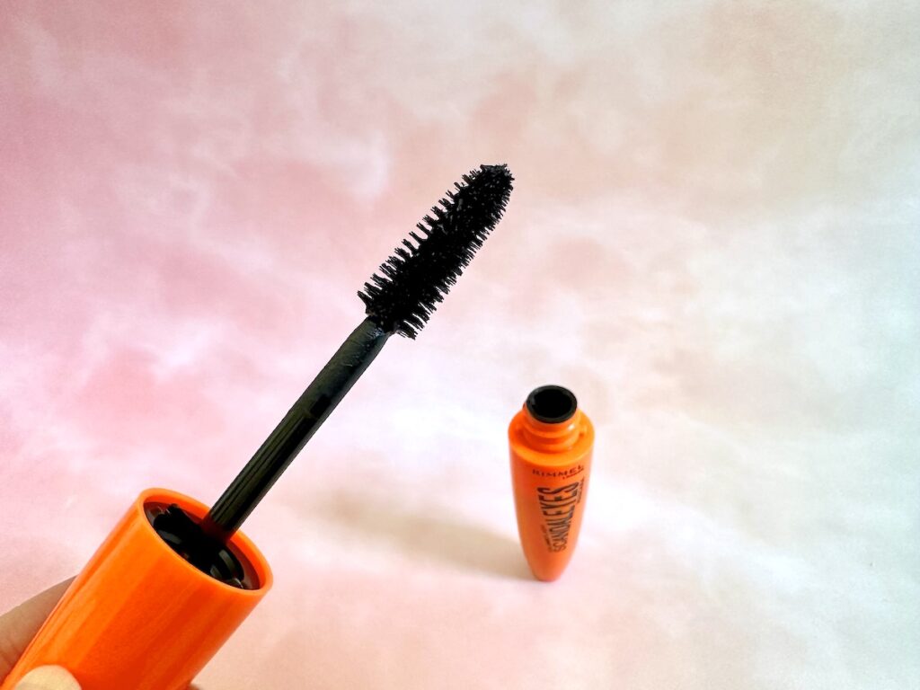 Rimmel Scandaleyes Mascara wand and open tube in background.